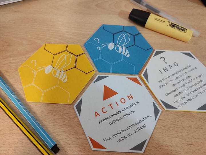 Hachi Action and Info learning cards on a desk.